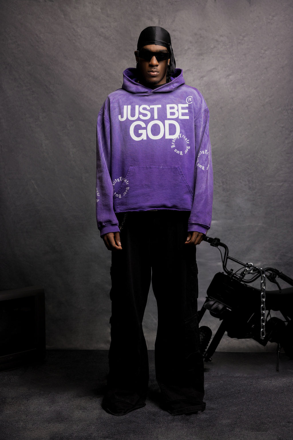 Legaxy Studios JUST BE GOD hoodie shown in black with white lettering, front view, casual streetwear style.